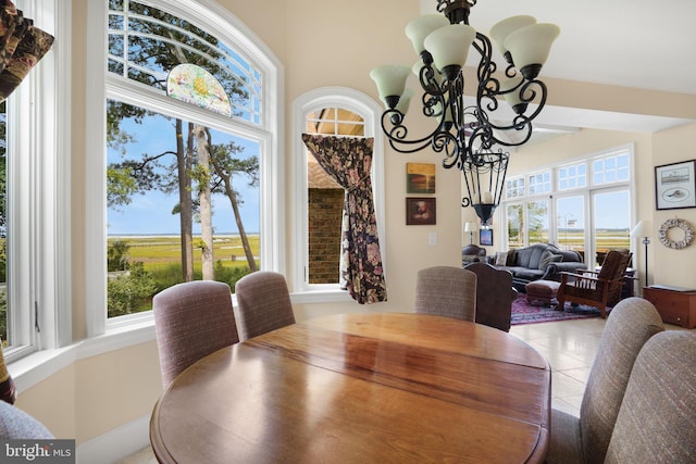 dining room with a healthy amount of sunlight, tile patterned floors, and a notable chandelier