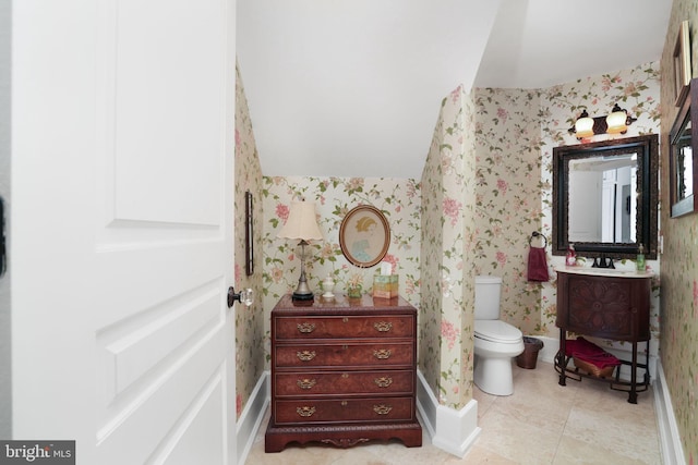 bathroom with wallpapered walls, baseboards, toilet, tile patterned flooring, and vanity