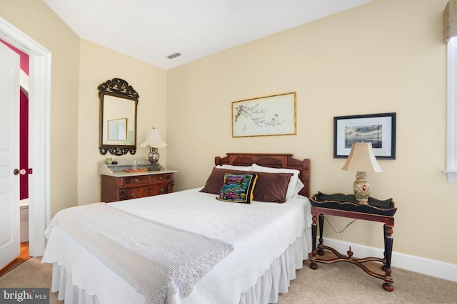 bedroom with visible vents, baseboards, and light colored carpet