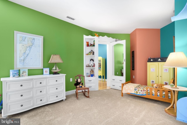 bedroom featuring visible vents and light carpet