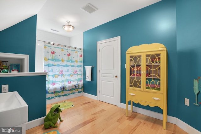 bathroom featuring visible vents, baseboards, and wood finished floors