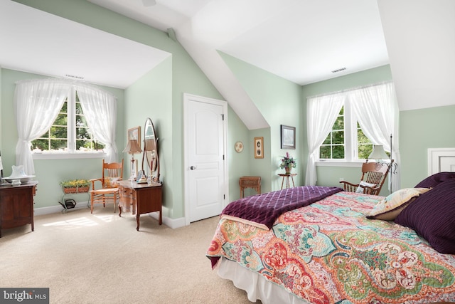 bedroom with light carpet, vaulted ceiling, visible vents, and baseboards