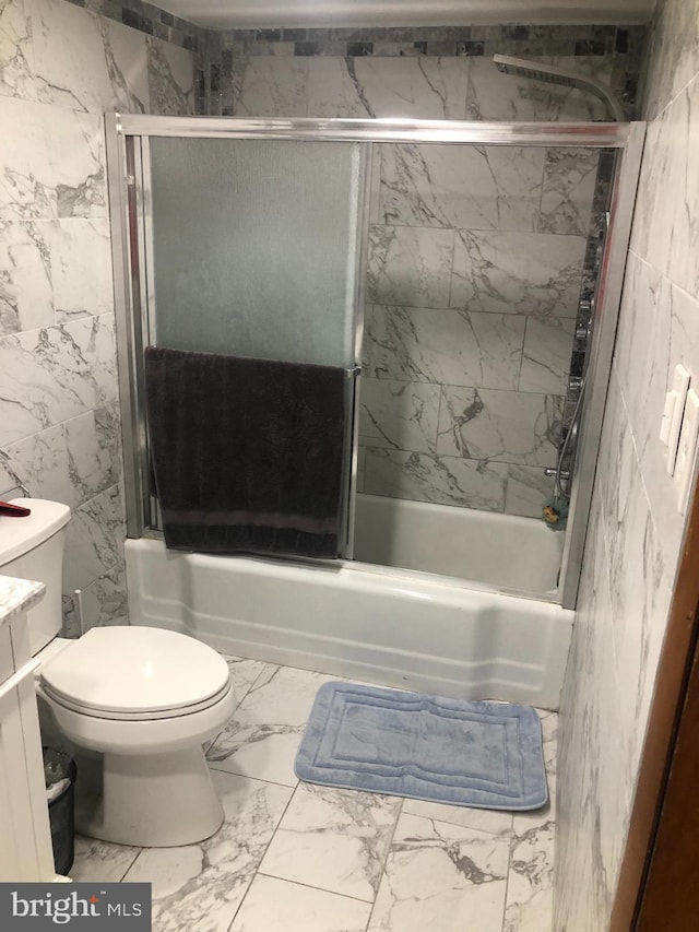 full bathroom with toilet, vanity, and bath / shower combo with glass door