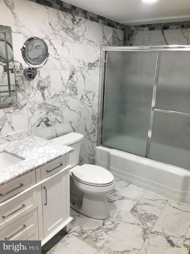 full bathroom featuring enclosed tub / shower combo, vanity, and toilet