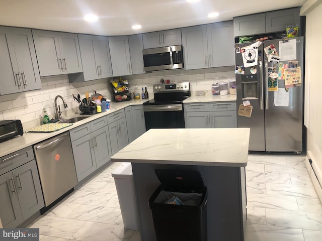 kitchen with tasteful backsplash, sink, gray cabinets, and stainless steel appliances