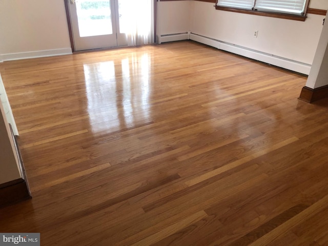 unfurnished room featuring light hardwood / wood-style floors and baseboard heating