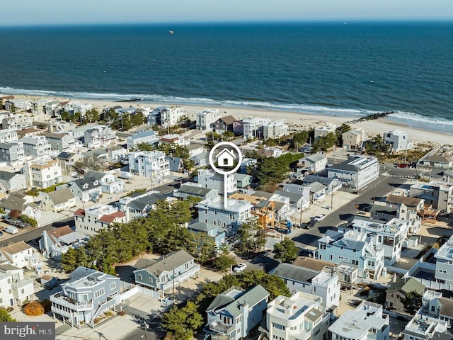 birds eye view of property with a water view and a beach view