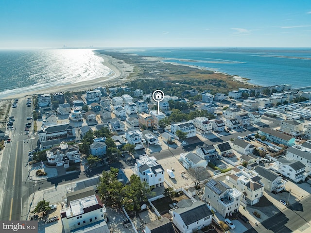 birds eye view of property with a water view and a beach view