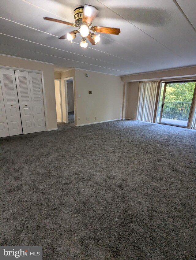 unfurnished bedroom with dark carpet and ceiling fan