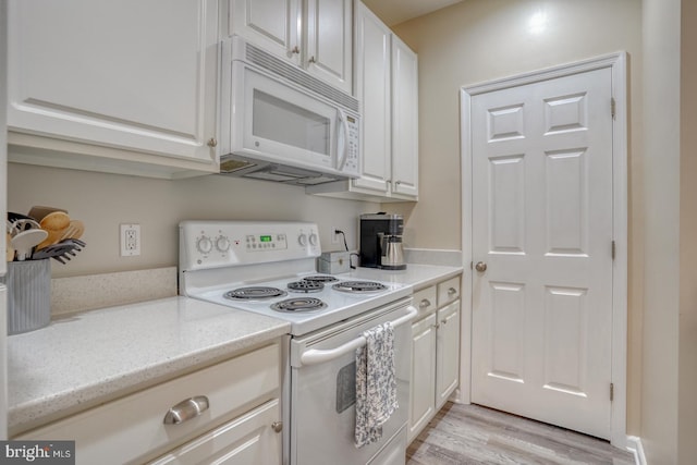 kitchen featuring white cabinetry, light hardwood / wood-style flooring, and white appliances