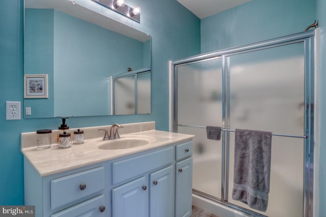 bathroom featuring vanity and a shower with shower door