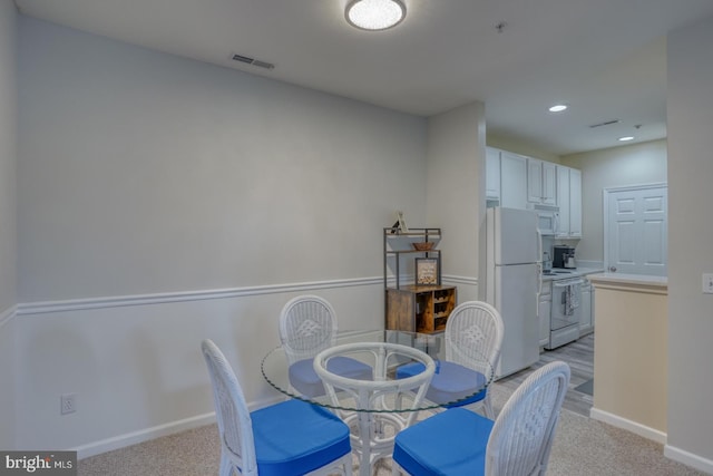 dining area featuring light colored carpet