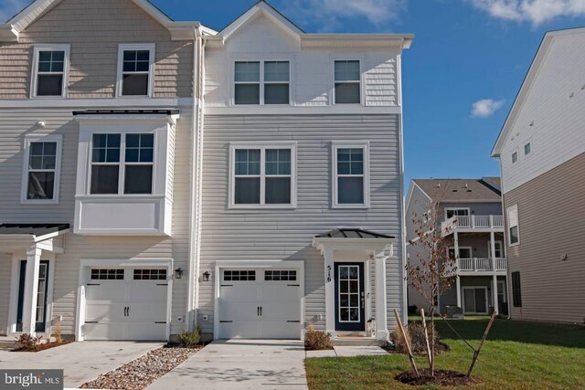 multi unit property featuring a garage, a balcony, and a front yard