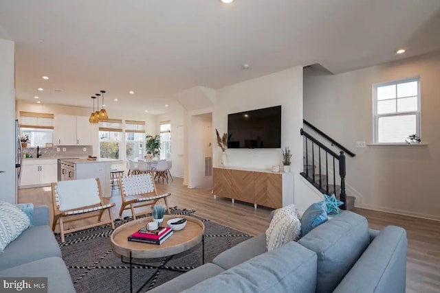 living room featuring sink, plenty of natural light, and light hardwood / wood-style floors