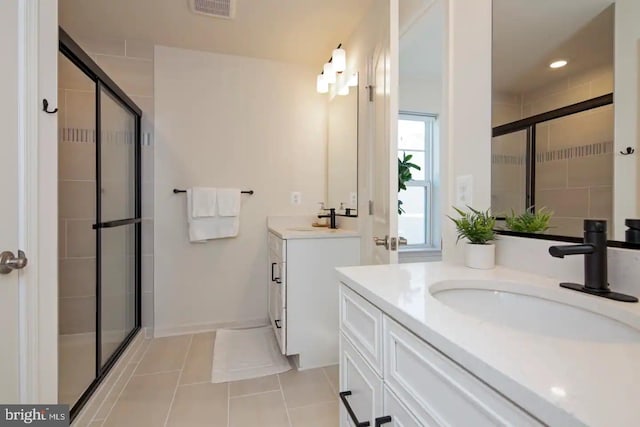 bathroom featuring vanity, tile patterned flooring, and a shower with door