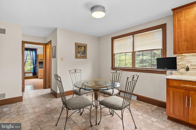 tiled dining space featuring plenty of natural light