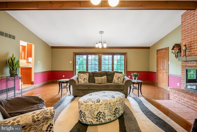 living room featuring a brick fireplace, brick wall, hardwood / wood-style floors, and vaulted ceiling