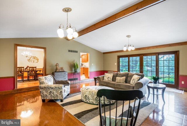 living room with lofted ceiling with beams, wood-type flooring, and a chandelier