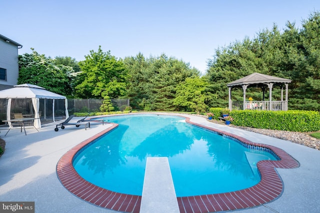 view of swimming pool with a patio area, a diving board, and a gazebo