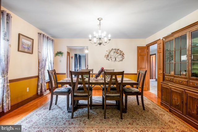 dining room featuring light wood-type flooring and a chandelier