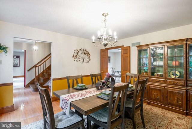 dining area featuring light hardwood / wood-style flooring and a chandelier