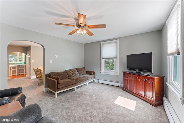 carpeted living room with ceiling fan, a baseboard radiator, and a healthy amount of sunlight