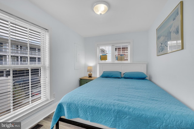 bedroom featuring wood finished floors and visible vents