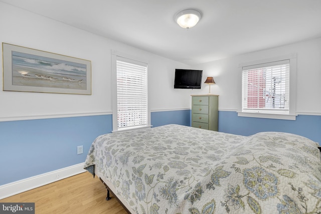 bedroom with baseboards and wood finished floors