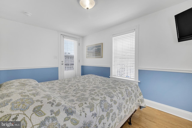 bedroom featuring multiple windows and light wood-type flooring