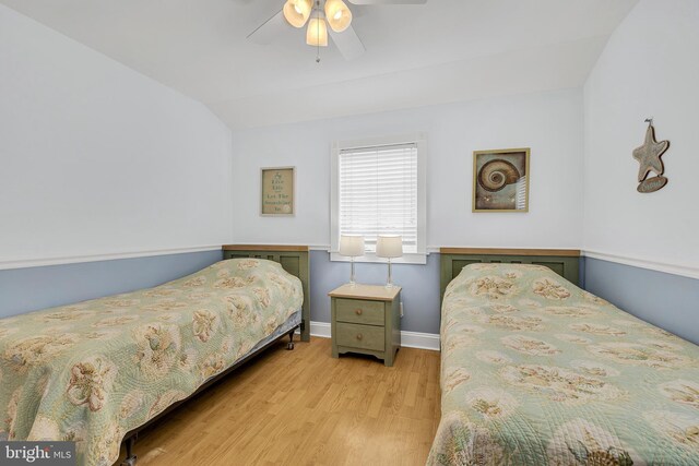 bedroom featuring ceiling fan, light hardwood / wood-style floors, and vaulted ceiling