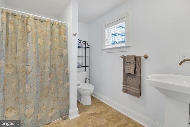 bathroom featuring toilet, tile patterned flooring, and a shower with curtain