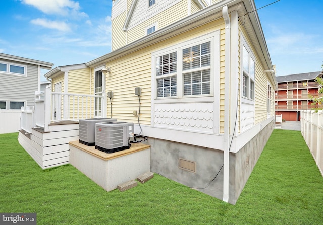 exterior space with crawl space, fence, central AC, and a yard