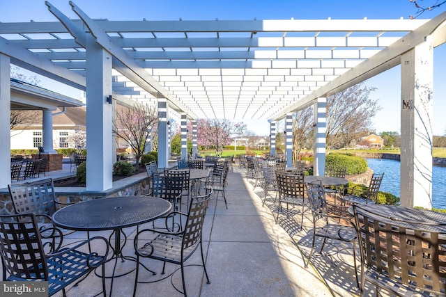 view of patio / terrace with a pergola, outdoor dining area, and a water view