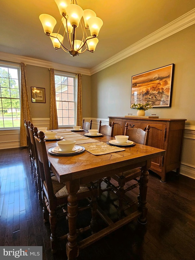 dining space with a wainscoted wall, dark wood-type flooring, crown molding, and a notable chandelier