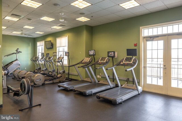 exercise room featuring a drop ceiling, french doors, baseboards, and visible vents