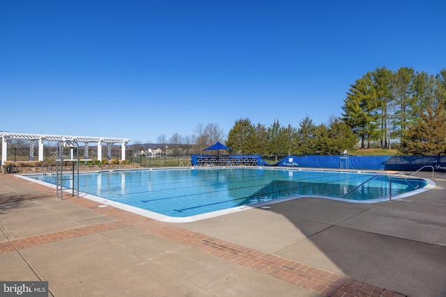 community pool featuring a patio area, a pergola, and fence