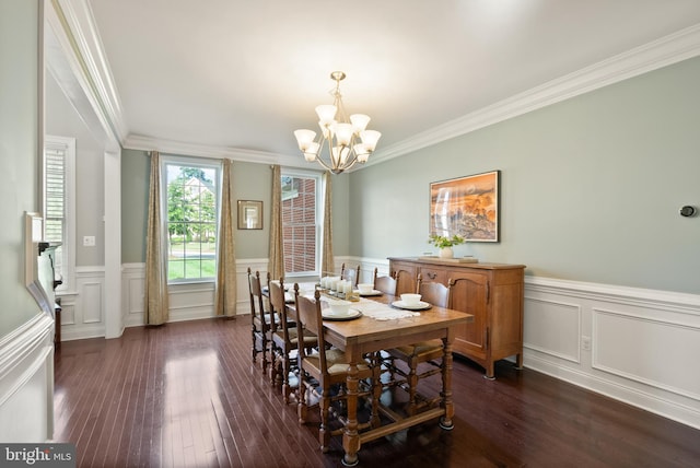 dining area featuring a chandelier, dark wood-type flooring, and ornamental molding