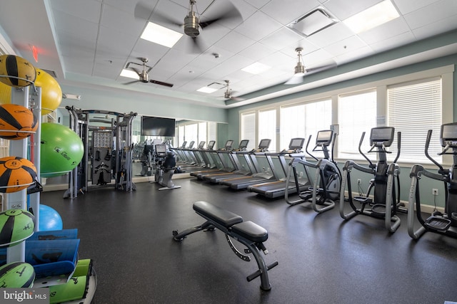 exercise room featuring baseboards and a drop ceiling