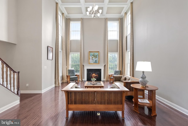 living area featuring a wealth of natural light, baseboards, a high ceiling, and wood finished floors