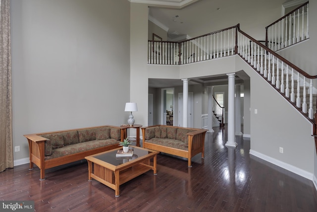 living area with stairway, baseboards, ornate columns, and wood finished floors