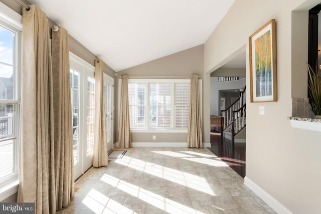 interior space featuring stairway, lofted ceiling, and baseboards