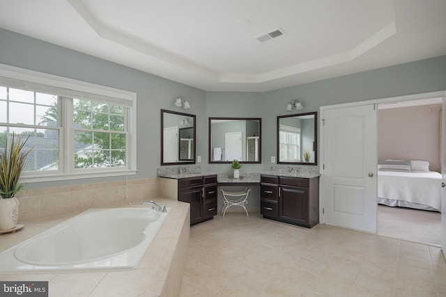 full bath with vanity, a garden tub, visible vents, ensuite bathroom, and a raised ceiling