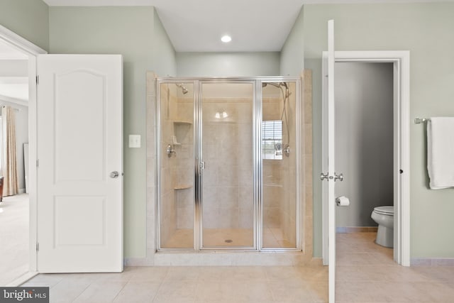 full bathroom with tile patterned floors, a stall shower, toilet, and baseboards