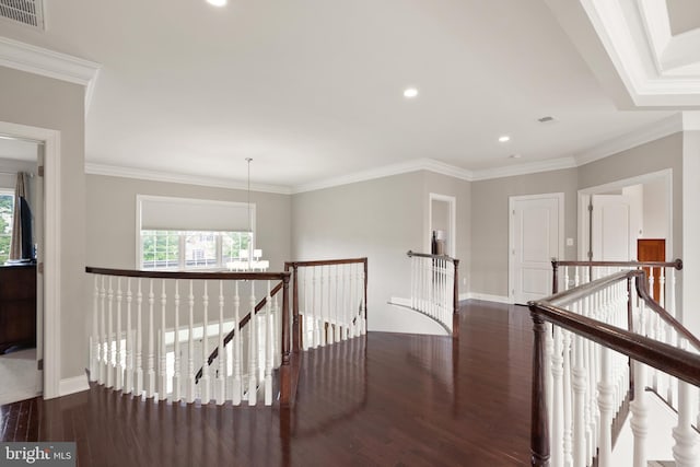 hall featuring visible vents, baseboards, ornamental molding, an upstairs landing, and wood finished floors