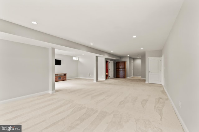 finished below grade area featuring light carpet, recessed lighting, and baseboards