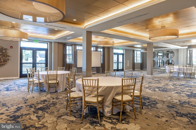 carpeted dining area featuring a tray ceiling, french doors, plenty of natural light, and visible vents