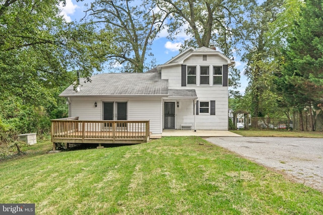 rear view of house with a lawn and a deck