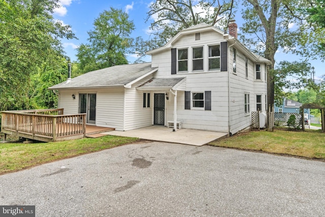 view of front of property with a wooden deck and a front yard