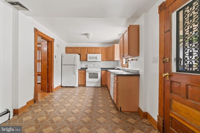 kitchen featuring a baseboard radiator, sink, tile patterned flooring, and white appliances