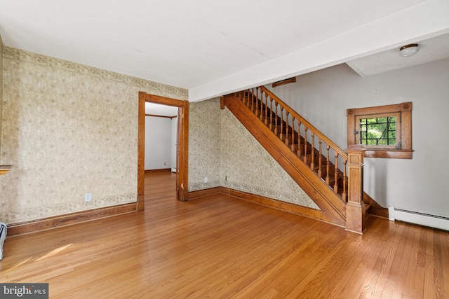 unfurnished living room with hardwood / wood-style floors and a baseboard radiator